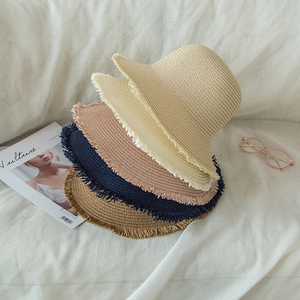 Detail of five-color woven straw sun hats with unique fringed edges for summer vacation