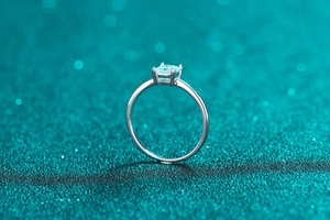 Macro shot of silver ring featuring a rectangular light blue stone and four-prong setting