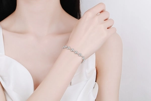 Detail of silver clover bracelet featuring sparkling moissanite stones and adjustable chain