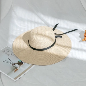 Close-up of the finely woven straw texture and elegant black bow on the sun hat
