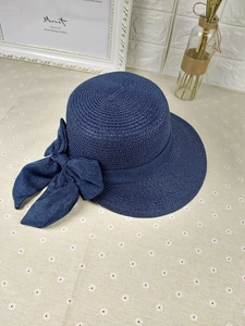 Macro detail of navy blue woven sun hat featuring a large decorative side bow knot