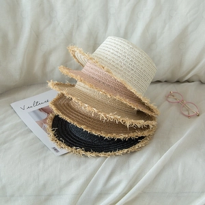 Detail of multi-color straw hats with frayed edges for sun protection in summer