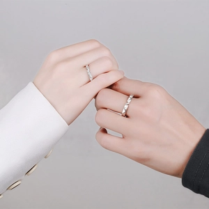 Minimalist S925 sterling silver couple rings with moissanite on a simple grey background