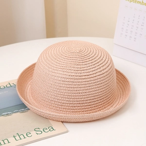 Texture détaillée du chapeau de soleil tressé rose pêche avec bord roulé pour femme