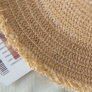 Close-up of natural straw weave texture and frayed edge detail of the summer sun hat