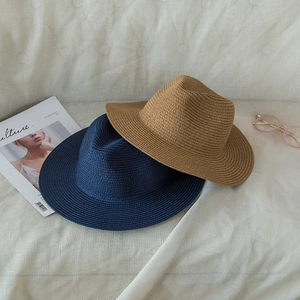 Detail of navy and khaki straw fedoras showing fine woven texture and flat top design