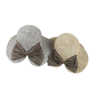Two woven summer sun hats with large brown bows in navy and natural straw styles