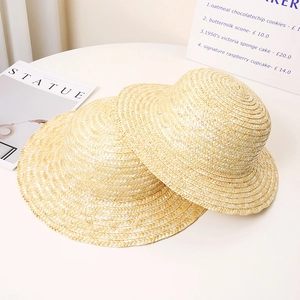 Handcrafted straw boater hats in two sizes for summer sun protection on a white table