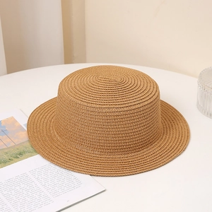 Detailed close-up of a khaki woven straw sun hat with a flat top and wide brim design