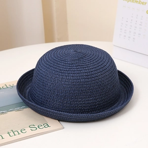 Détail d'un chapeau de soleil bleu marine avec texture tressée en spirale et bord roulé
