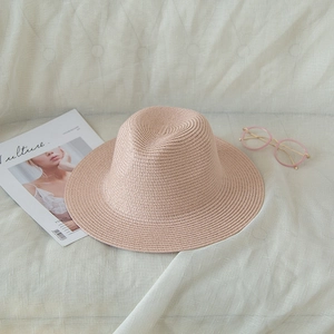 Light pink woven straw sun hat with wide brim for summer travel and beach vacations