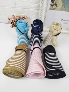 Detail of colorful striped straw sun visors in various colors with foldable elastic bands