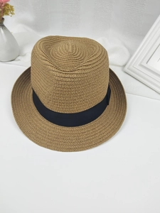 Vue détaillée d'un chapeau de paille tressé avec ruban noir et texture de qualité