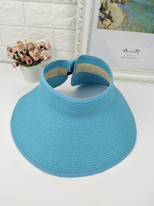 Detailed texture of a foldable bright blue straw sun visor with a wide protective brim
