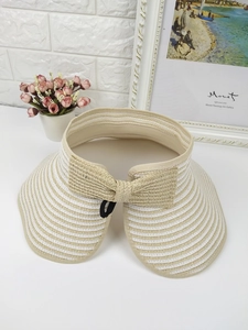 Close-up of foldable straw sun visor with striped brim and elegant bow decoration