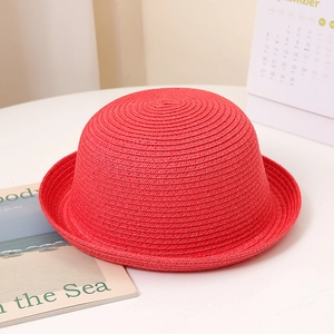 Gros plan détaillé sur le tissage en spirale d'un chapeau de soleil en paille rouge