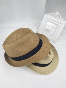 Vue détaillée de chapeaux de paille beige et tan avec rubans noirs superposés