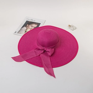 Flat lay of wide brim sun hat with elegant bow and stylish lifestyle accessories