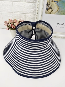 Detail view of woven blue and white striped straw sun hat with adjustable cord