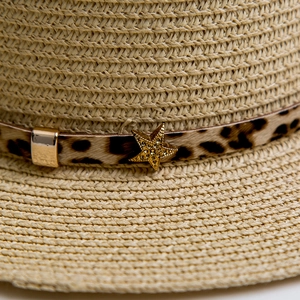 Natural straw sun hat with leopard print band and decorative gold star accessory