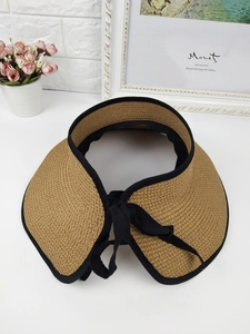 Detailed straw sun visor featuring natural fiber texture and stylish black bow trim