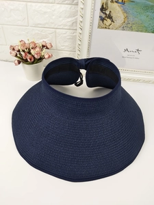 Detail of navy straw sun visor hat with wide brim and adjustable back bow tie