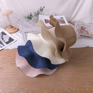 Detail of wide brim straw hats in pink, blue, beige and khaki colors for sun protection