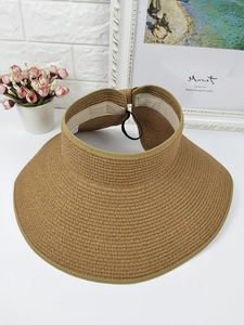 Close-up of wide brim straw sun hat with paper fiber texture and sweatband detail