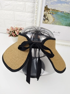 Detail showing the straw texture and black bow tie on a summer visor sun hat