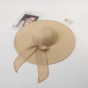 Elegant wide-brim straw hat with a stylish bow ribbon on a minimalist background