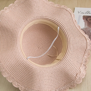 Detailed view of women straw sun hat featuring wavy scalloped edges and inner sweatband
