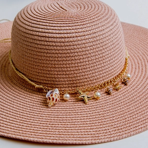 Pink woven straw hat with golden starfish shells and pearls beach vacation accessory