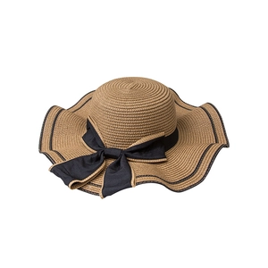 Women's wide brim straw sun hat with wavy edges and black ribbon bow for beach sun protection