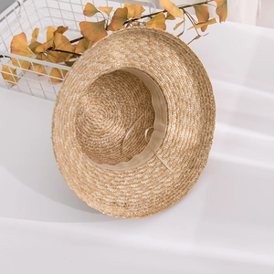Detail of straw sun hat featuring interior sweatband and adjustable drawstrings