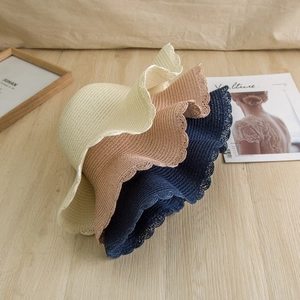 Detail of summer straw hats with wavy brims in cream, khaki, and navy blue finishes