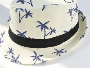Close-up of summer paper straw fedora with blue coconut tree prints and black ribbon