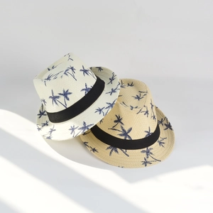 Detail of woven straw hats featuring navy palm tree prints and wide black decorative bands