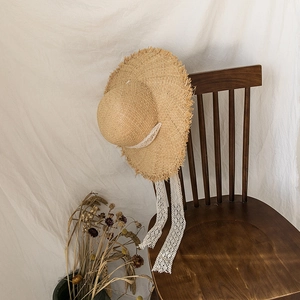 Ethnic straw sun hat with lace ribbons and frayed edges in a French vintage style