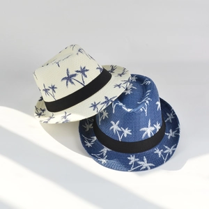 Close-up of woven straw fedora hats with tropical palm tree patterns for men
