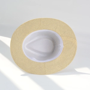 Detailed view of the internal sweatband and wash label inside the beige straw sun hat