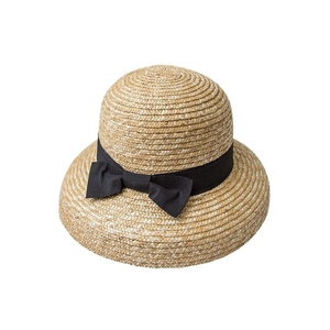 Straw sun hat with dome top and black bow ribbon decoration on a white background
