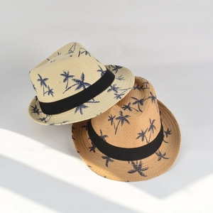 Detail view of woven paper straw fedora hat featuring tropical blue palm tree patterns