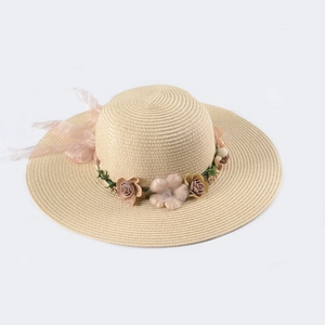 Detailed view of women's straw sun hat featuring 3D floral accents and sheer pink ribbon