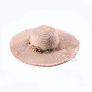 Close-up of pink straw hat featuring delicate floral accents and a chiffon ribbon detail