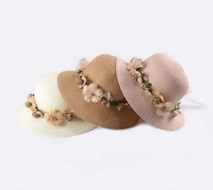 Dettaglio di cappelli di paglia con ghirlande floreali e trama intrecciata traspirante