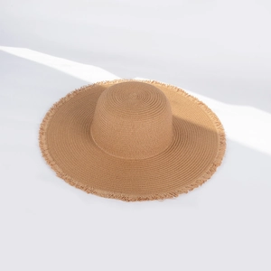 Detail of wide brim straw sun hat with frayed fringe edges and fine khaki paper weave texture