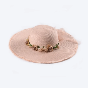 Detail of wide brim straw sun hat with floral ribbon and fringe edge in soft pink
