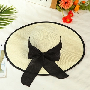 Detail view of the wide brim straw hat featuring a large black chiffon bow for sun protection