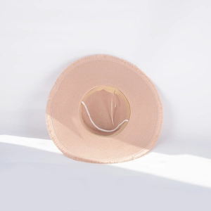 Detail of light pink wide brim straw hat with fringe edge and sun shadow effect