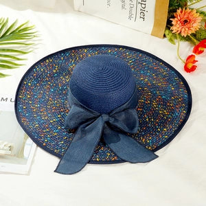 Detail of navy wide-brim straw hat with colorful specks and a large decorative bow